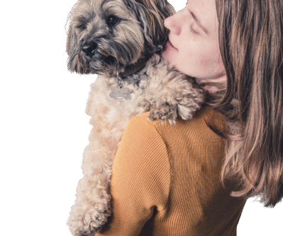 woman-carrying-dog-while-standing-against-wall